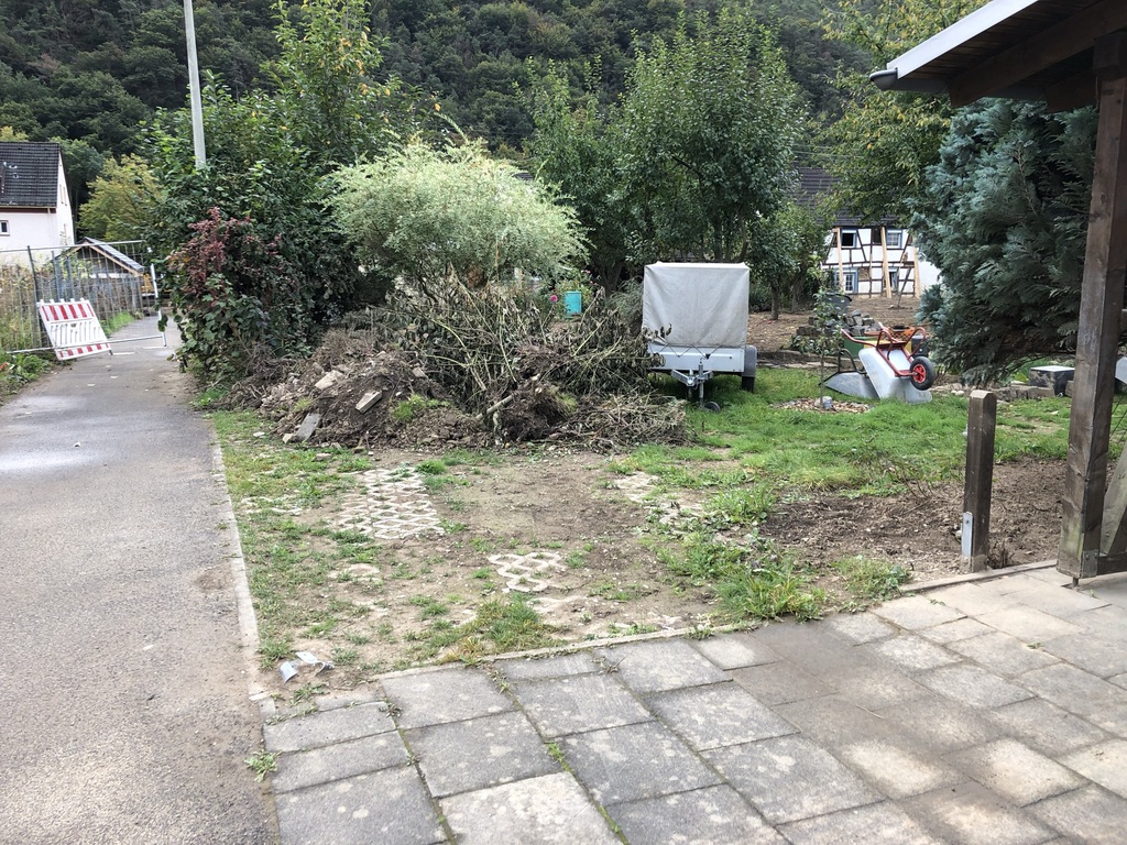 Bild 1 Gartenmauer und PKW Stellplatz an einem Einfamilienhaus einer 4-köpfigen Familie